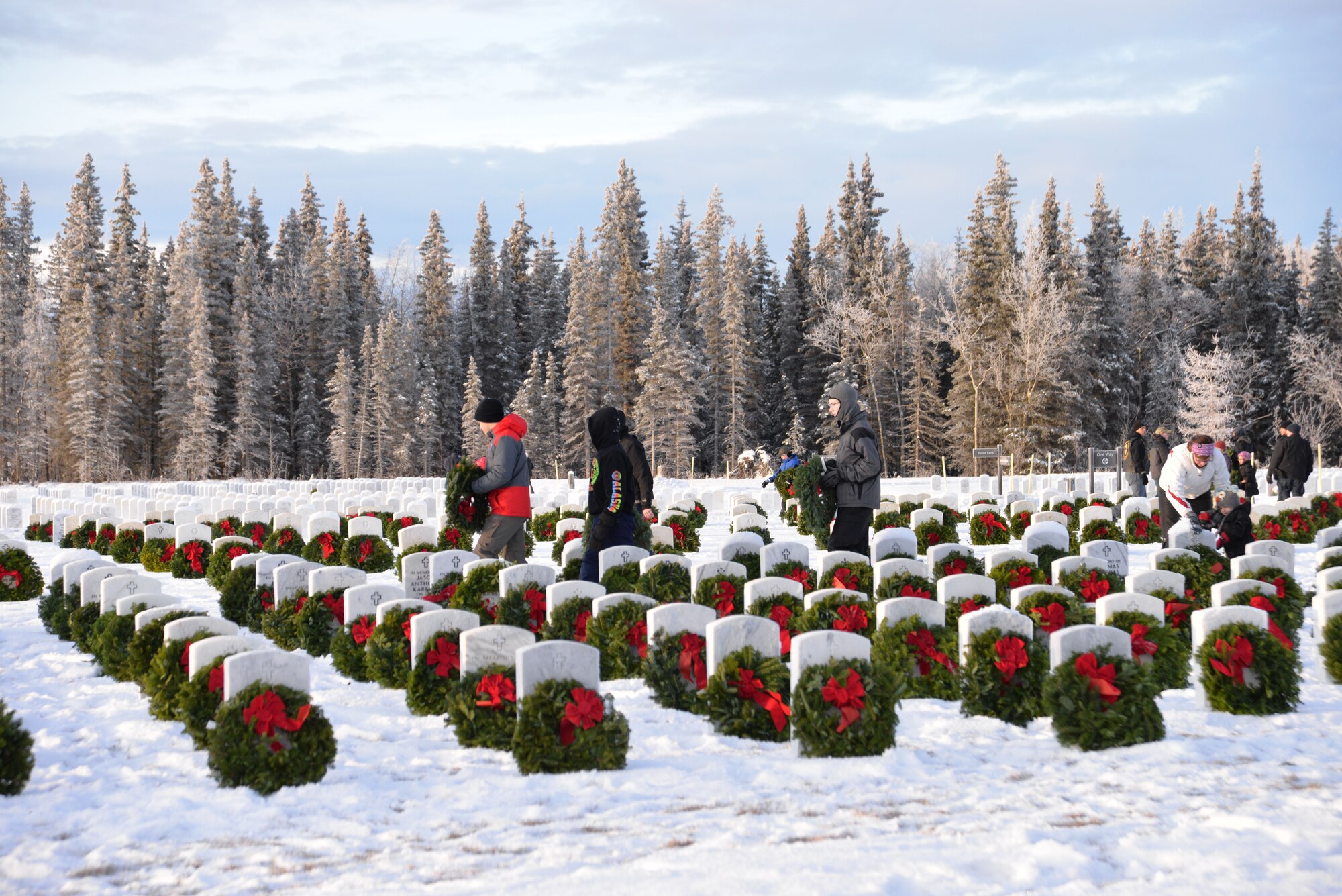 Volunteers place wreaths on gravestones at Fort Richardson National Cemetery Dec. 13 during the local observance of “Wreaths Across America,” a nationwide program honoring fallen veterans each holiday season. (U.S. Air Force photo/Song Johnson) 