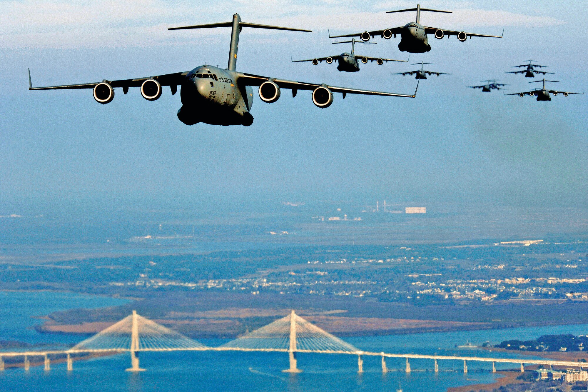 U.S. Air Force C-17 Globemaster III aircraft fly in formation over the Cooper River Bridge in Charleston, South Carolina, during a strategic brigade airdrop exercise involving a 12-ship formation. The exercise demonstrates the teamwork of active duty airmen, reservists and civilians. The Air Force's improvements to fuel use and cargo loading procedures garnered one of the awards. (U.S. Air Force photo/Staff Sgt. Richard Rose/Released)
