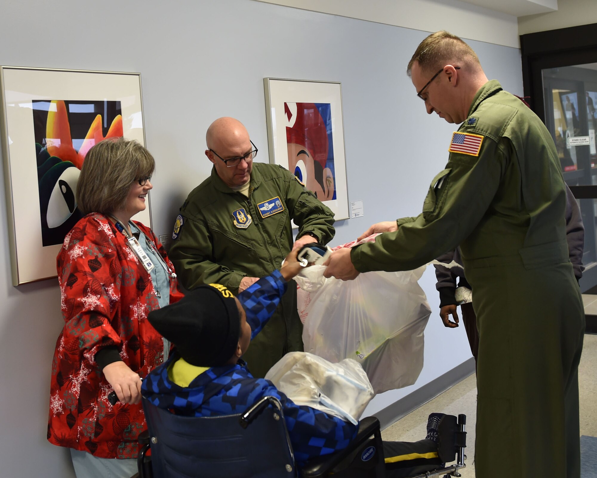 BOARDMAN, Ohio—Lt. Col. John “Chinky” Kochansky and Lt. Col. Chris Zwetzig, navigators with Youngstown Air Reserve Station’s 757th Airlift Squadron, visit and give gifts to a child at Akron Children’s Hospital Dec. 17, 2014. Six Service members from Youngstown Air Reserve Station went to the hospital to deliver toys and visit children as a community outreach event. U.S. Air Force photo/Eric M. White
