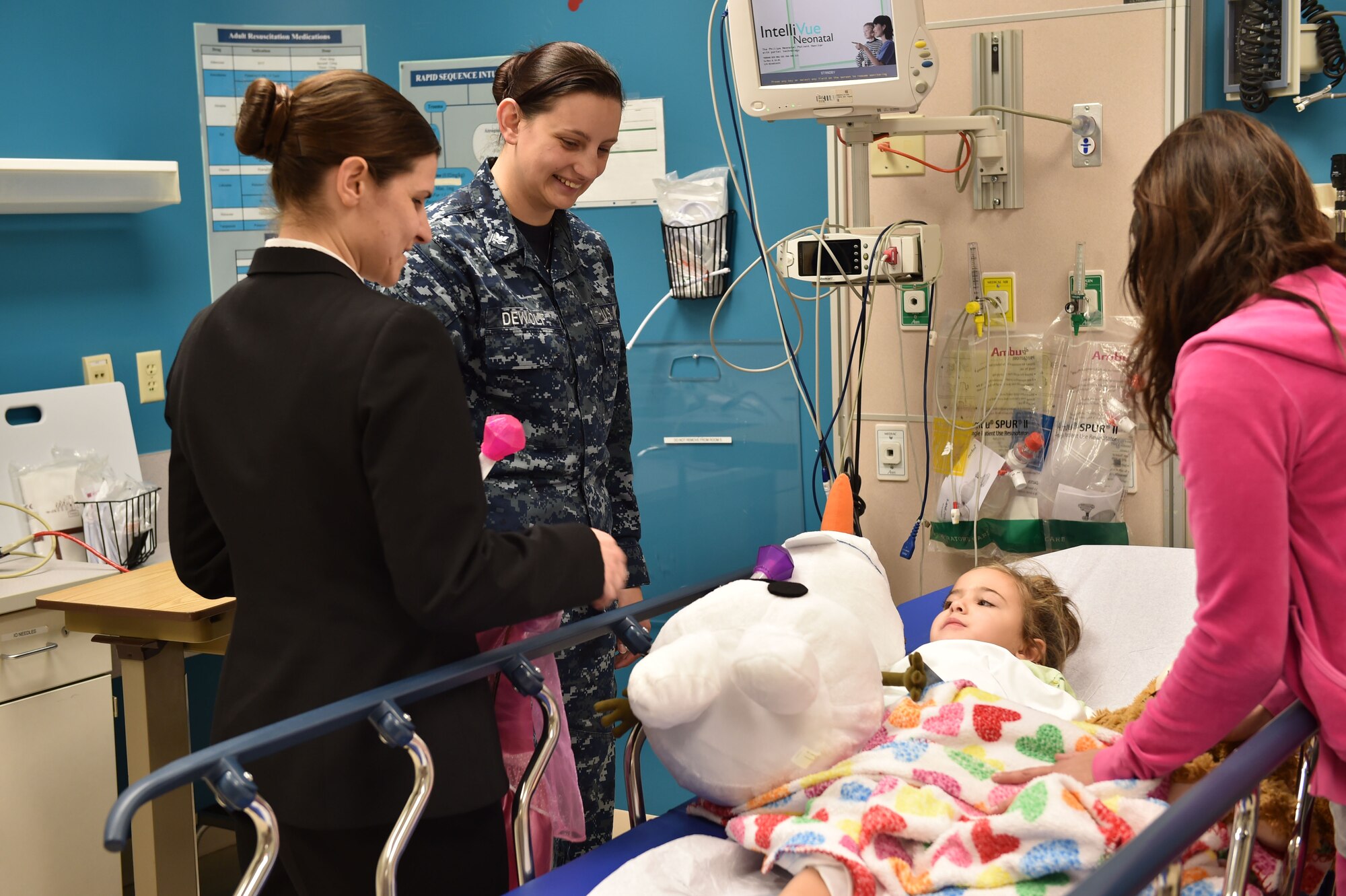 BOARDMAN, Ohio—U.S. Navy Petty Officer 1st Class Elizabeth Fleming and Petty Officer 3rd Julia DeWolf, both from the Naval Operational Support Center Youngtown, visit a child at Akron Children’s Hospital Dec. 17, 2014. Six Service members from Youngstown Air Reserve Station went to the hospital to deliver toys and visit children as a community outreach event. U.S. Air Force photo/Eric M. White