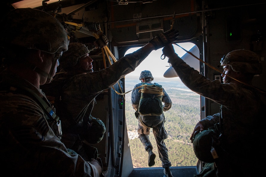 U.S. Air Force Master Sgt. Justin Geers, second from left, 823d Base Defense Squadron jumpmaster, grabs a jumper’s static line as another Airman jumps from a C-17 Globemaster Dec. 12, 2014, over Moody Air Force Base, Ga. As each jumper leaves the aircraft, the jumpmaster grabs their static-line to avoid tangles. (U.S. Air Force photo by Airman 1st Class Ryan Callaghan/Released)
