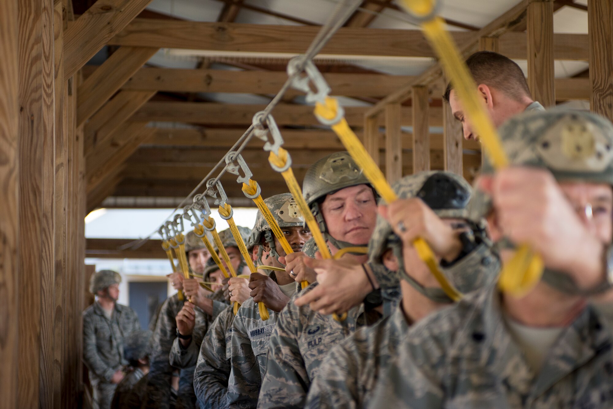 Members of the 820th Base Defense Group hold on to a static-line during pre-jump training Dec. 11, 2014, at Moody Air Force Base, Ga. The Airmen spent several hours training the day before a real-world static-line jump. (U.S. Air Force photo by Senior Airman Sandra Marrero/Released)
