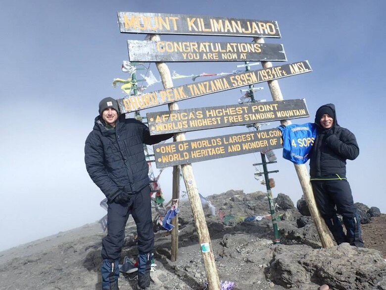 Capt. Rodrigo Ocampo, 4th Space Operations Squadron spacecraft engineer, shows his 4 SOPS pride after reaching the summit of Mount Kilimanjaro along with his friend John Gaebler in early October. (Courtesy photo)  
