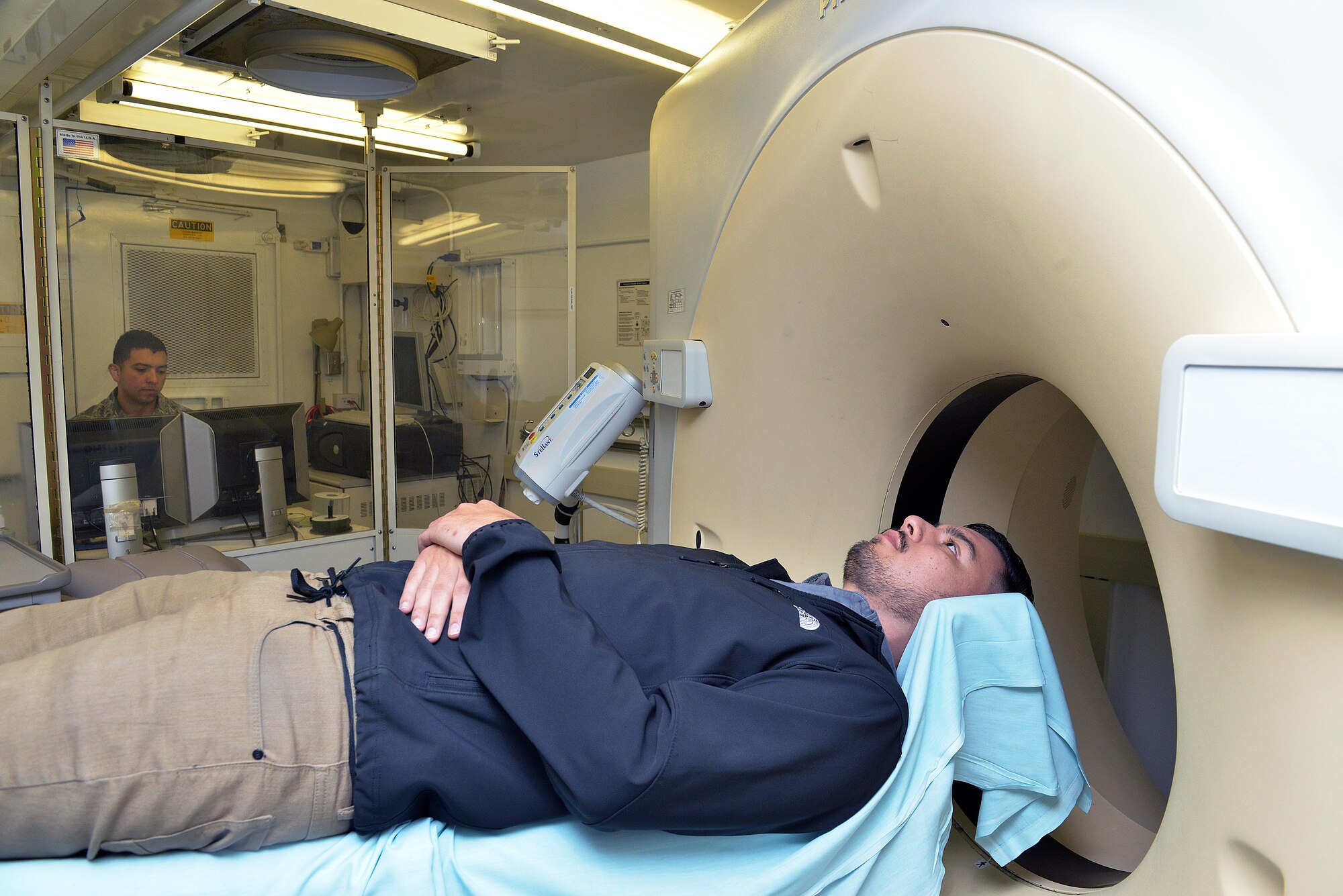 Staff Sgt. Juan Henao, 31st Surgical Operations Squadron diagnostic imaging technician, monitors Alex Ayala, 31st Medical Support Squadron, during a CT scan, Dec. 16, 2014, at Aviano Air Base, Italy. A CT scan is a diagnostic medical test that produces multiple images from the inside of the body so doctors can better diagnose a patient. (U.S. Air Force photo/Airman 1st Class Ryan Conroy) 