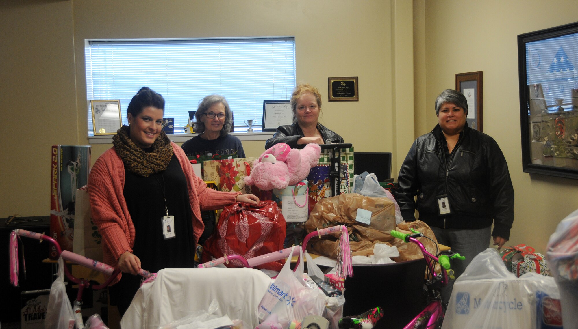 Diamond Cantrell, left, Sandy Goodwin, Sheila Dolan and Lorri Ramero, all employees of the Arkansas Department of Human Services, pose for a photo Dec. 8, 2014, at the 188th Wing, Ebbing Air National Guard Base, Fort Smith, Ark. Members of the 188th Wing sponsored more than 75 children, ensuring a happy holiday for local kids in need. The gifts were all purchased by 188th Wing members. (U.S. Air National Guard photo by Airman 1st Class Cody Martin/released)