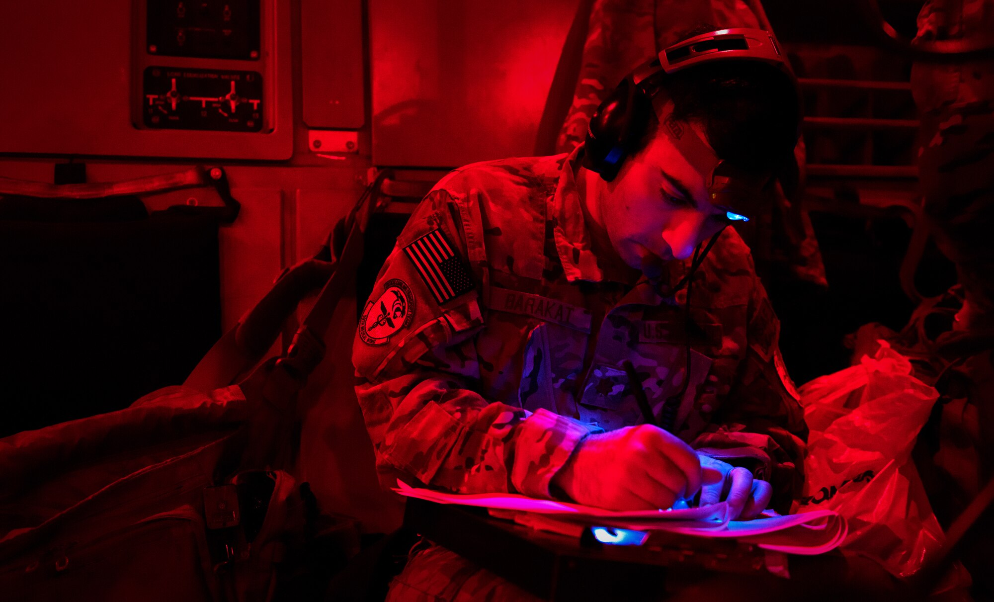 Maj. Michael Barakat, 10th Expeditionary Aeromedical Evacuation Flight emergency medicine doctor, writes notes during a flight from Bagram Airfield, Afghanistan Dec. 14, 2014. Members of the 10th EAEF provided in-flight medical care to an American Soldier wounded in Afghanistan while he was being transported to Landstuhl Regional Medical Center.   (U.S. Air Force photo/Staff Sgt. Katherine Tereyama/RELEASED)