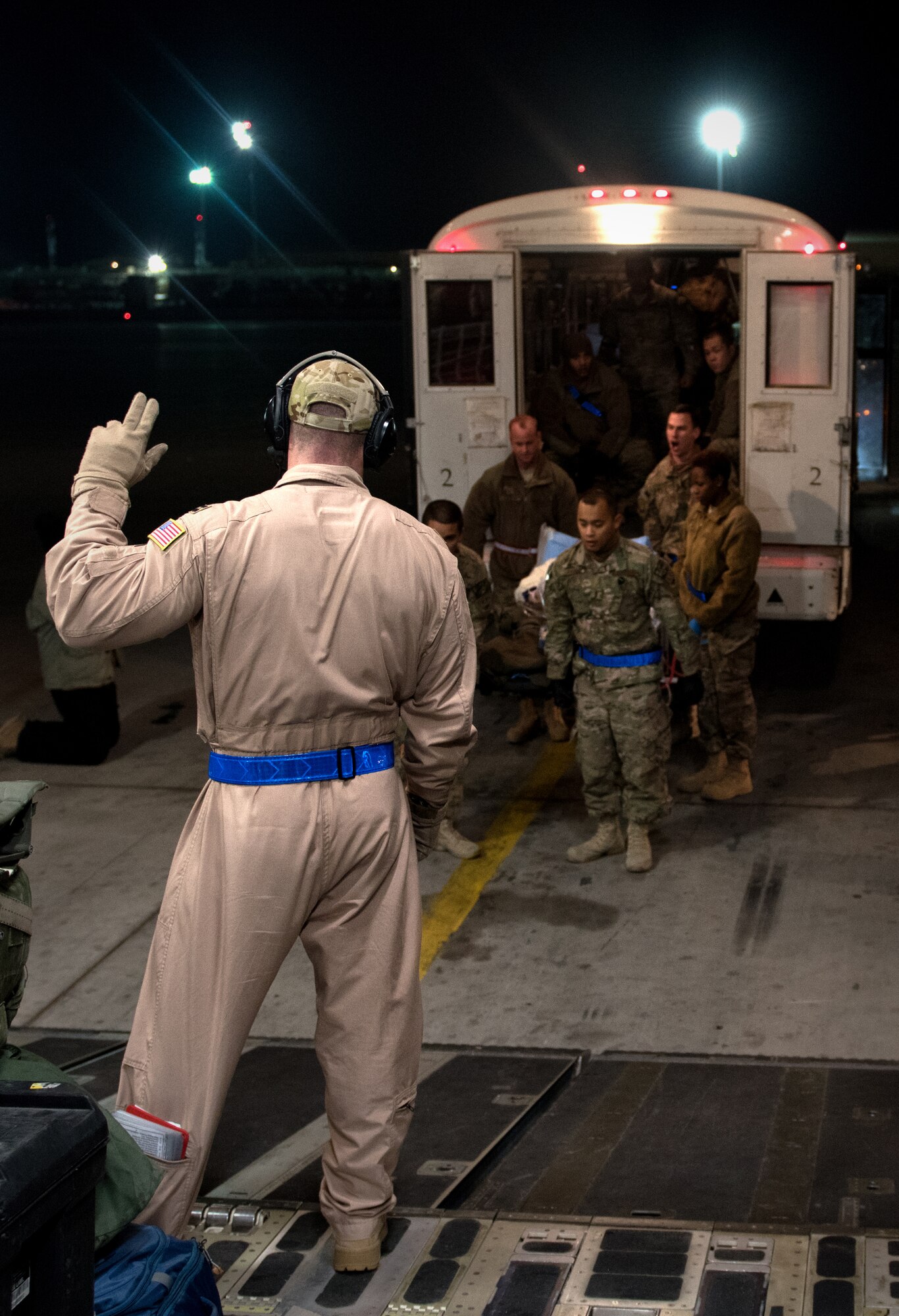 Capt. John Brennan, 10th Expeditionary Aeromedical Evacuation Flight nurse, guides litter bearers onto a C-17 transporting patients from Bagram Airfield, Afghanistan to Ramstein Air Base, Germany to receive medical treatment at Landstuhl Regional Medical Center Dec. 14,2014. The 10th EAEF provides in-flight medical care to patients transitioning from deployed locations (U.S. Air Force photo/Staff Sgt. Katherine Tereyama/RELEASED)