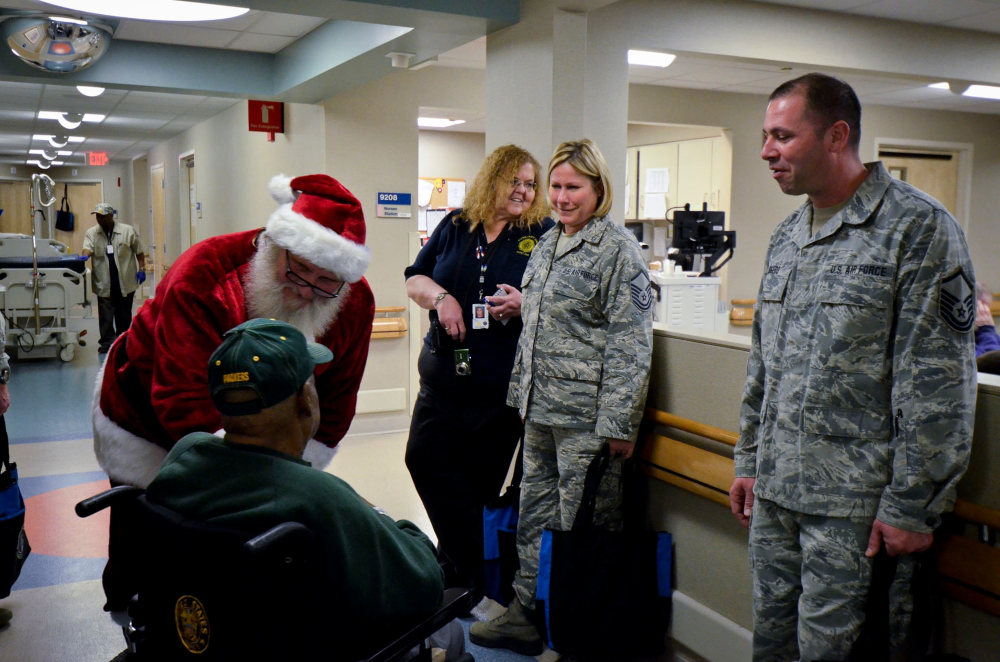 Santa and U.S. Airmen with the 128th Air Refueling Wing visit with a patient while passing out gifts to veterans at the Clement J. Zablocki VA Medical Center, Milwaukee Dec. 10, 2014.  (U.S. Air National Guard photo by Tech. Sgt. Jenna Lenski/Released)