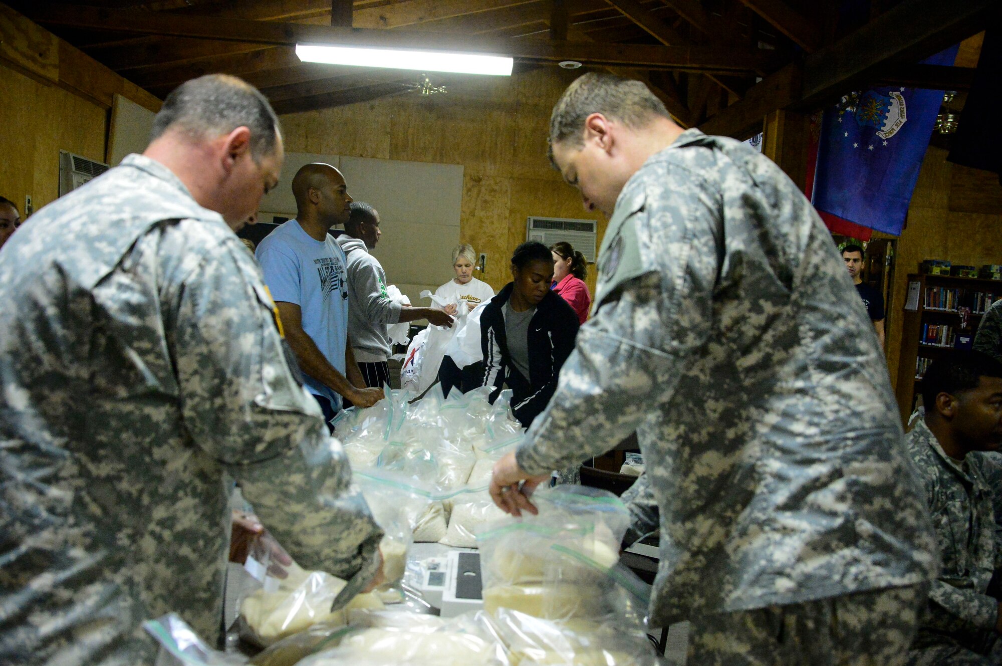 Volunteers gather at the Chapel’s activity room to help fill 130 bags of food on Soto Cano Air Base, Honduras, Dec. 11, 2014.  The food will be donated to families in the village of Mira Valle, La Paz, Honduras when volunteers from Soto Cano AB head off on the 58th Chapel Hike.  Since the chapel hikes originated in 2007, over 9,700 service members have donated over $170,000 and volunteered their time to deliver more than 209,000 pounds of food and supplies to several remote villages.