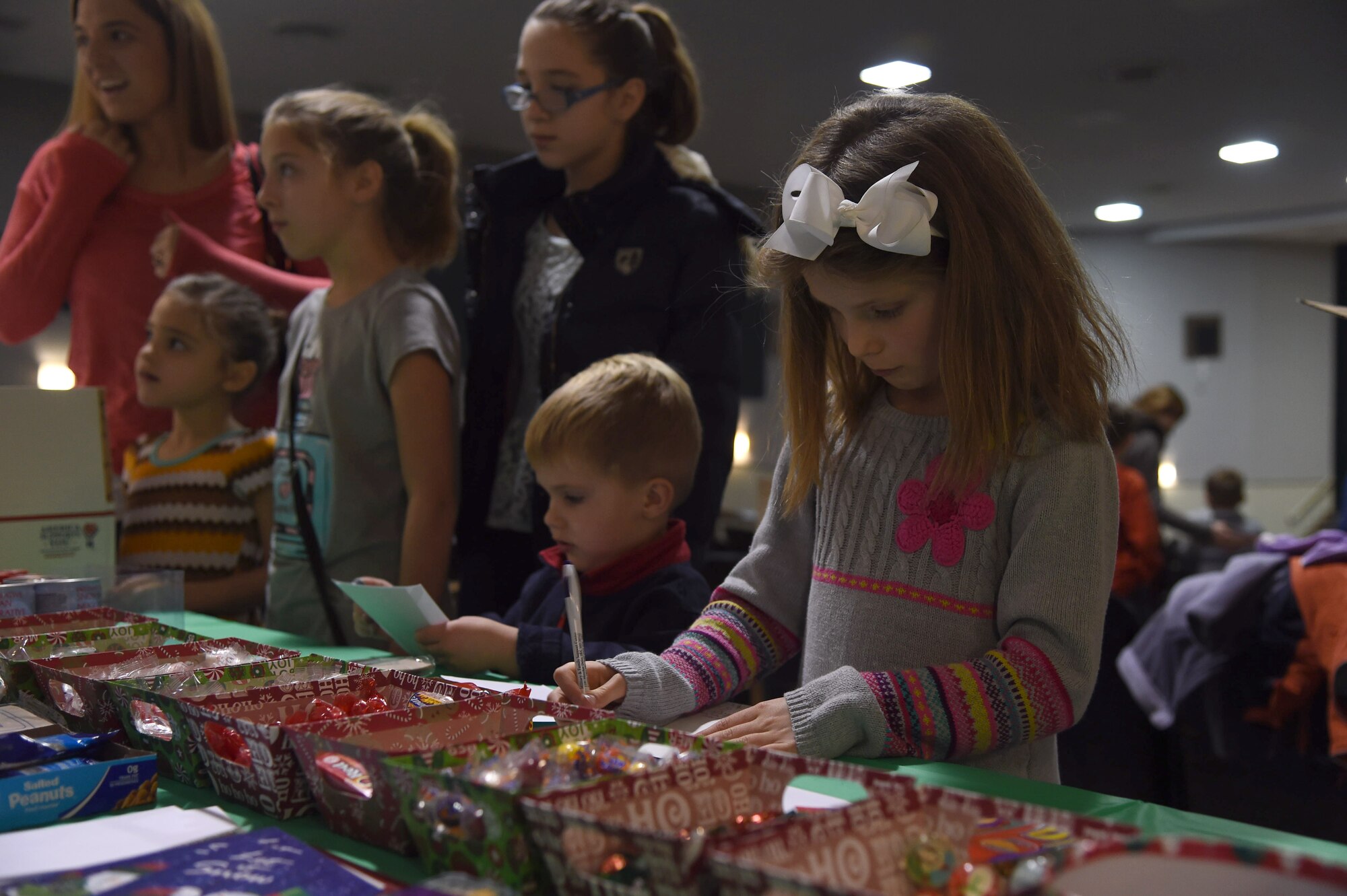 Hannah and Zack Zaiser, children of a deployed service member, decorate care packages before making cards and filling the boxes with goodies during the Hearts Apart Deployed Families Holiday Party, Dec. 13, 2014. Free family portraits, a scavenger hunt, DJ, food and giveaways were featured at the event. (U.S. Air Force photo/Airman 1st Class J.D. Maidens)