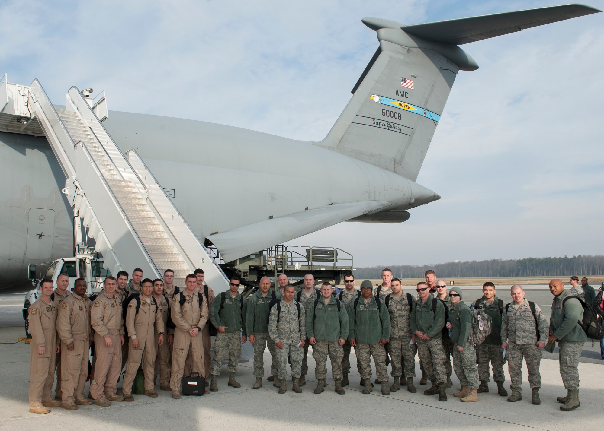 Team Dover members pose for a photo on the flight line Dec. 16, 2014, at Dover Air Force Base, Del. C-5M maintenance personnel were deployed four months in support of Afghanistan retrograde missions at a forward staging location in Southwest Asia. (U.S. Air Force photo/Airman 1st Class Zachary Cacicia)