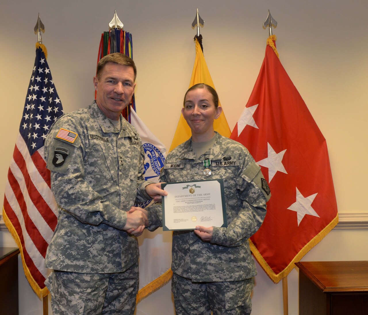 Lt. Gen. James C. McConville, the Army’s deputy chief of staff for personnel, presents Army 1st Sgt. Katrina Moerk with the citation for her Army Commendation Medal at the Pentagon, Dec. 15, 2014. Moerk received the medal for her efforts to address unprofessional online behavior by service members. U.S. Army photo