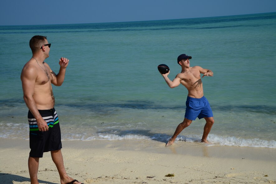 U.S. servicemembers throw a football around during the Qatari Minister of Defense’s Beach House event, Dec. 15, 2014, near Al Khor, Qatar. Qatar Minister of Defense Maj. Gen. Hamad Al-Attiyah, opens his beach house for ten days a year to U.S. servicemembers deployed to Al Udeid Air Base and Camp As Sayliyah, Qatar; their families, as well as Department of Defense civilians, as a gesture of friendship and good will. Some of the activities at the beach house event included deep sea fishing, jet skiing, four-wheeling and camel rides. (U.S. Air Force photo by Capt. Sarah Babcock)