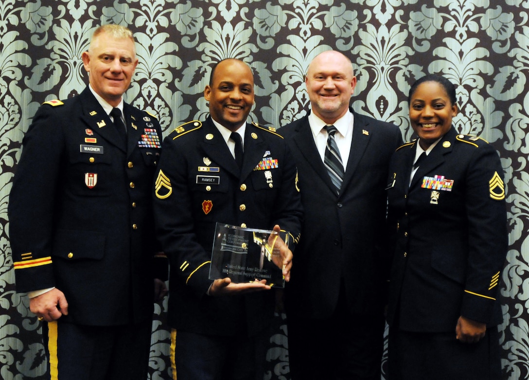 Standing with Michigan City, Ind., Mayor Ron Meer after being presented a Business Investment Award during the Economic Development Corporation of Michigan City’s 2014 Business Investment Awards Celebration, are Col. Kurt Wagner, 88th Regional Support Command; Staff Sgt. Antoine Ramsey; and Sgt. 1st Class Angel Avery, 624th Quartermaster Company. 