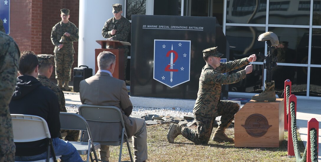 A Critical Skills Operator with 2nd Marine Special Operations Battalion, U.S. Marine Corps Forces Special Operations Command, pays tribute to a fallen warrior during a ceremony to unveil a stone memorial at the 2nd MSOB headquarters aboard Marine Corps Base Camp Lejeune, N.C., Dec. 12, 2014. The stone memorial was donated by the MARSOC Foundation to honor all fallen MARSOC Marines and sailors from 2nd MSOB. (Official United States Marine Corps photo and caption by Sgt. Donovan Lee/released)