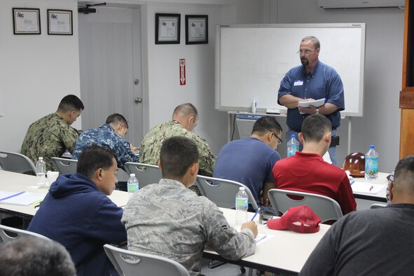 Scott Strader, a concrete inspection manager from the Utah Department of Transportation, provides academic lessons on concrete to Airmen, U.S. Navy Sailors and Department of Defense civilians attending the field concrete testing course Dec. 11, 2014, in Mangilao, Guam. The course participants spent one day learning academics and the second in the field during the two-day course. (U.S. Air Force photo by Capt. Naseem Ghandour/Released) 