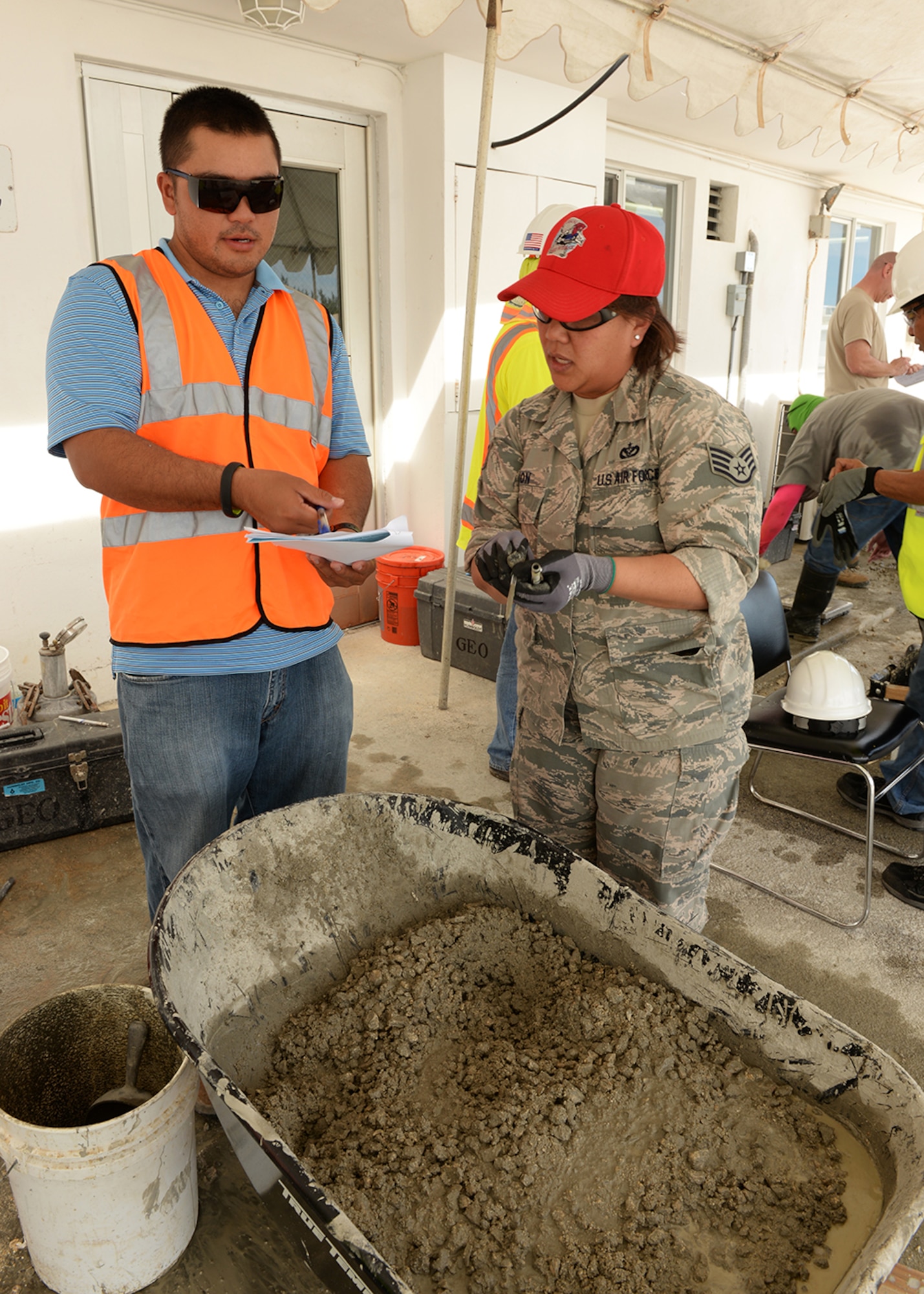 Staff Sgt. Ruth Aguon, Guam Air National Guard 254th RED HORSE Squadron, reviews concrete specifications with an American Concrete Institute instructor during a field concrete testing course in Mangilao, Guam Dec 11. RED HORSE joined with U.S. Naval Base Guam Sailors and Department of Defense civilians to become certified in field testing concrete during a two-day course. (U.S. Air Force photo by Senior Airman Cierra Presentado/Released)