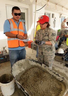 U.S. Air Force Staff Sgt. Ruth Aguon, Guam Air National Guard 254th RED HORSE Squadron, reviews concrete specifications with an American Concrete Institute instructor during a field concrete testing course in Mangilao, Guam, Dec 11, 2014. RED HORSE joined with U.S. Naval Base Guam Sailors and Department of Defense civilians to become certified in field testing concrete during a two-day course. (U.S. Air Force photo by Senior Airman Cierra Presentado/Released) 
