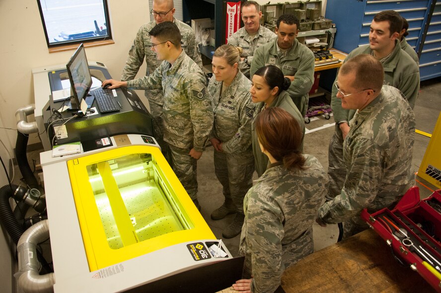 Staff Sgt. Dustin McGrath, 92nd Aircraft Maintenance Squadron sortie support specialist, shows the capabilities of the new laser etcher to members of the 92nd Contracting Squadron during a tour Dec. 5, 2014, at Fairchild Air Force Base, Wash. The new laser etcher was recently installed in the 92nd AMXS sortie support section and is able to conduct extremely precise etching on tools and other products.  Its capabilities standardize the way tools are labeled, saving manpower and resources. (U.S. Air Force photo/Airman 1st Class Nicolo J. Daniello)