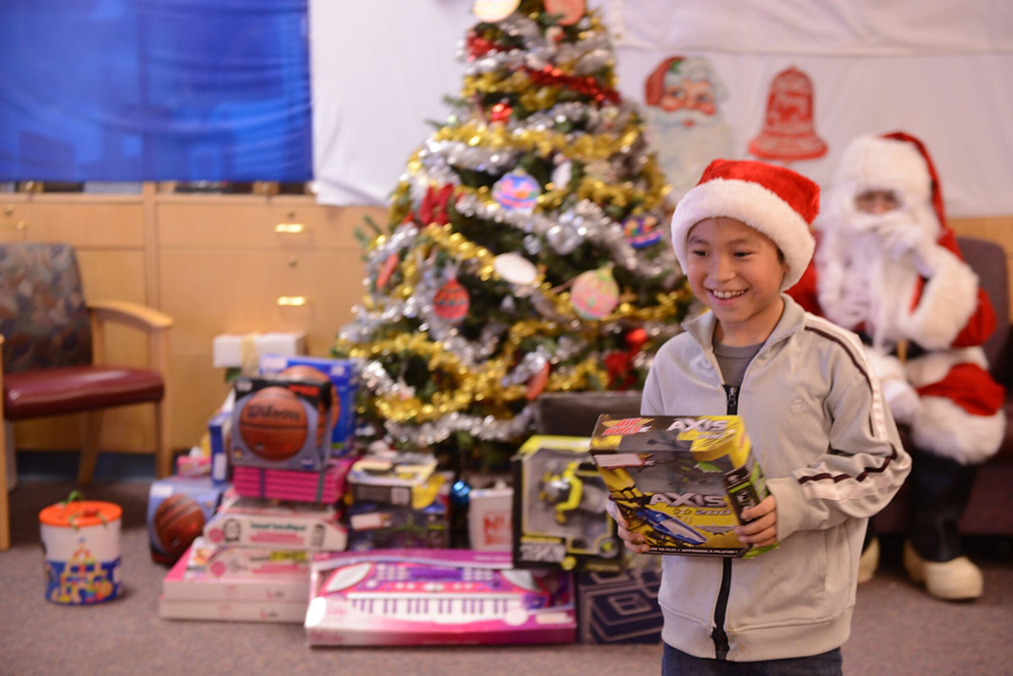 A boy in Buckland, Alaska, excitedly leaves a Marine Corps Santa with present in hand. The Marines of the Inspector-Instructor Detachment, Military Police Company D, 4th Law Enforcement Battalion, annually conduct Operation Cool Runnings, in which they deliver toys to isolated schools. On the way, they pick up some arctic survival training. (U.S. Air Force photo/Airman 1st Class Kyle Johnson)