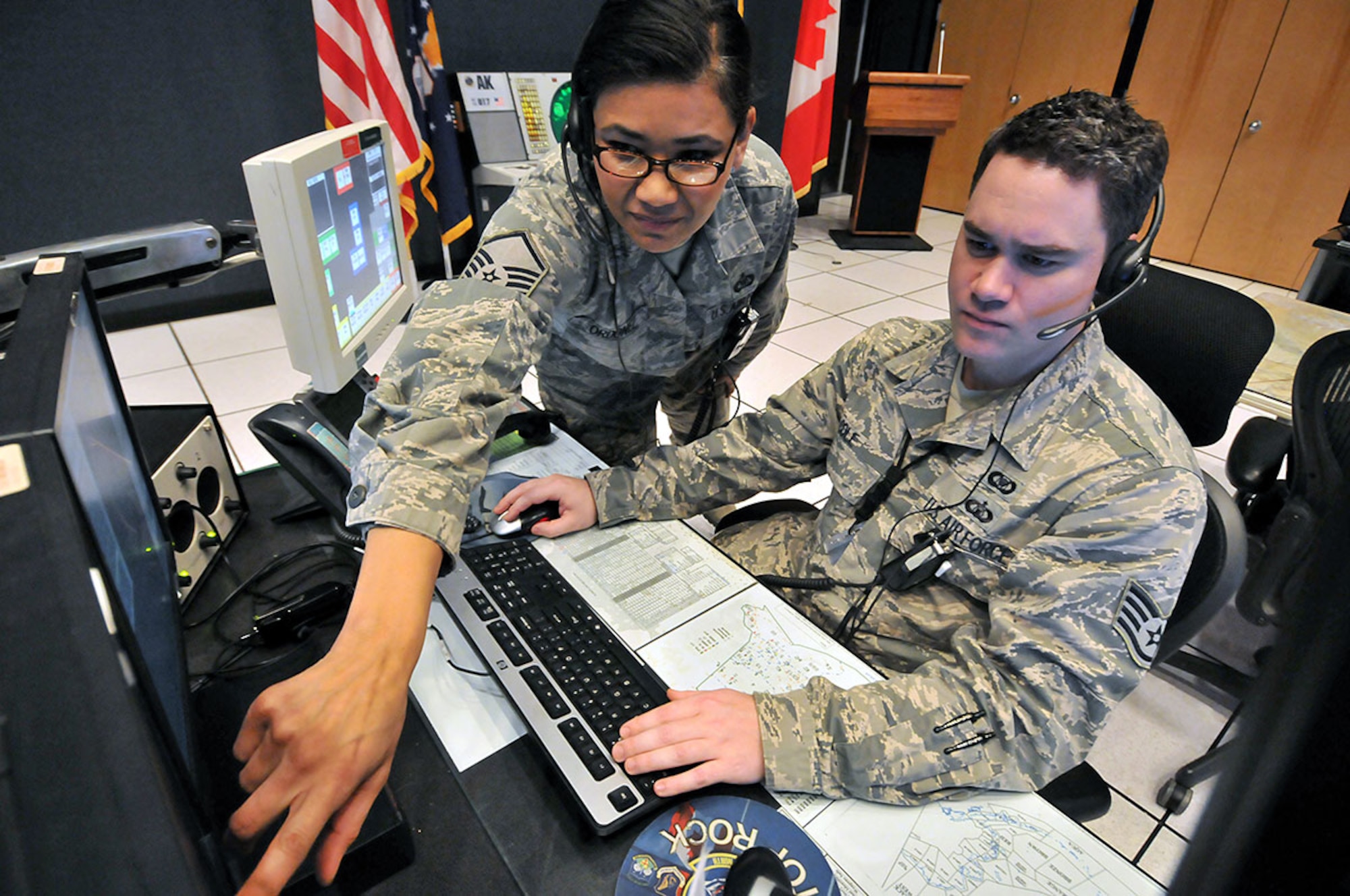 Air National Guard Master Sgt. SanJuan Ordonez (left), 176th Air Defense Squadron surveillance noncommissioned officer-in-charge, provides direction to Air National Guard Staff Sgt. Richard Cole, 176th ADS tracking technician, as he tracks aircraft in Alaska air space at the Alaskan NORAD Region Regional Air Operations Center. U.S. and Canadian service members monitor Santa each Christmas, a mission ANR has accomplished for more than 50 years. (U.S. Air Force photo/Tech. Sgt. John Gordinier)