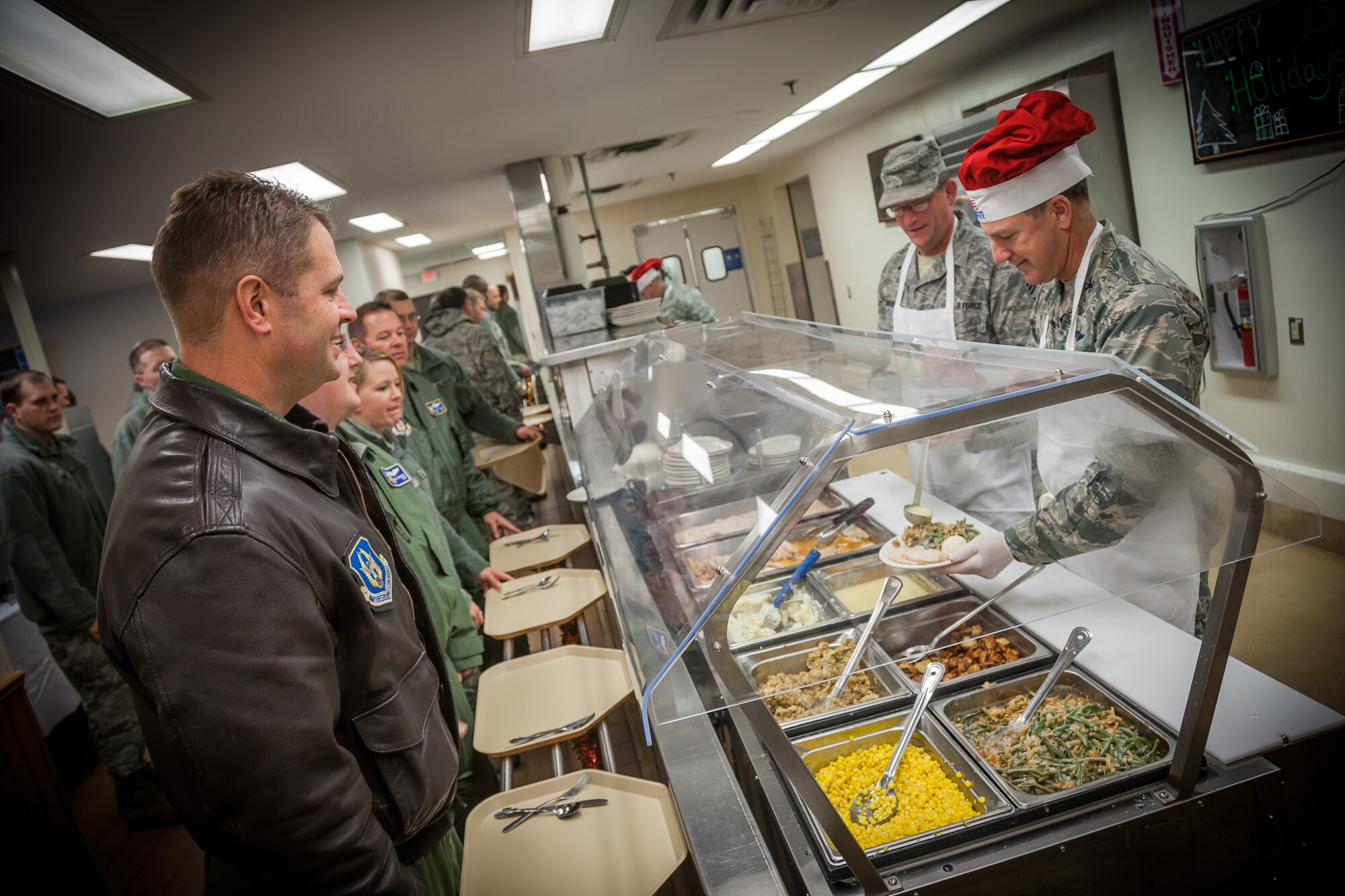 Col. Robert Graham, 934th Airlift Wing vice commander, and Chief Master Sgt. Richard Mathies, 934th Maintenance Group chief, plate up food for Airmen during the annual holiday dinner.  Tradition holds that the commanders and chiefs serve the meals at the dining facility during the holidays.  (U.S. Air Force photo by Shannon McKay/Released)