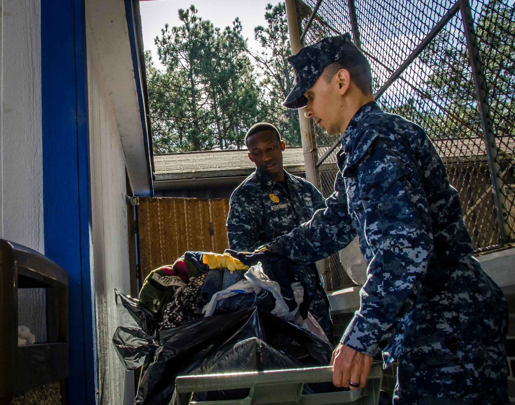 OS1 Strowder and FC1 Byrd, both assigned to the Naval Consolidated Brig Charleston, volunteer their time at Castaways Thrift Shop, Dec. 18, 2014, at Joint Base Charleston - Weapons Station, S.C. The volunteer opportunity was in accordance with CPO 365, a year-round training initiative that Chiefs Messes throughout the Navy take on to prepare first class petty officers to become chiefs. (U.S. Air Force Photo / Senior Airman Tom Brading)