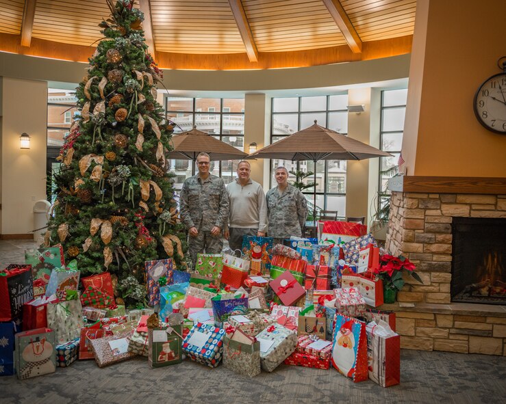 (Left to right) Maj. Troy Fiesel, Rick Pelzl, and Senior Master Sgt. Andy Regal, 934th Force Support Squadron, deliver Christmas presents for over 140 of the residents at the Minneapolis Veterans Home on behalf of members of the 934th Airlift Wing as part of the annual Adopt-A-Vet program.  The program allows participants to "adopt" a veteran to buy gifts for during the holiday season.  (U.S. Air Force photo by Shannon McKay/Released)