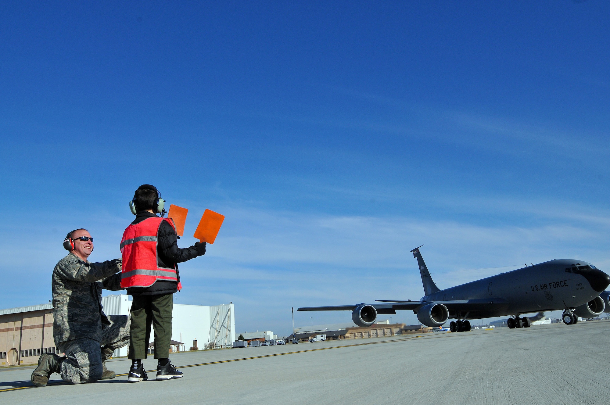 8-year-old Roman Pettograsso marshals a KC-135 Stratotanker with help from U.S. Air Force Tech. Sgt. Rich Turner Dec 11, 2014, at Rickenbacker Air National Guard Base, Ohio. The 121st Air Refueling Wing hosted Pettograsso for their inaugural pilot for a day program.(U.S. Air National Guard photo by Master Sgt. Ralph Branson)
