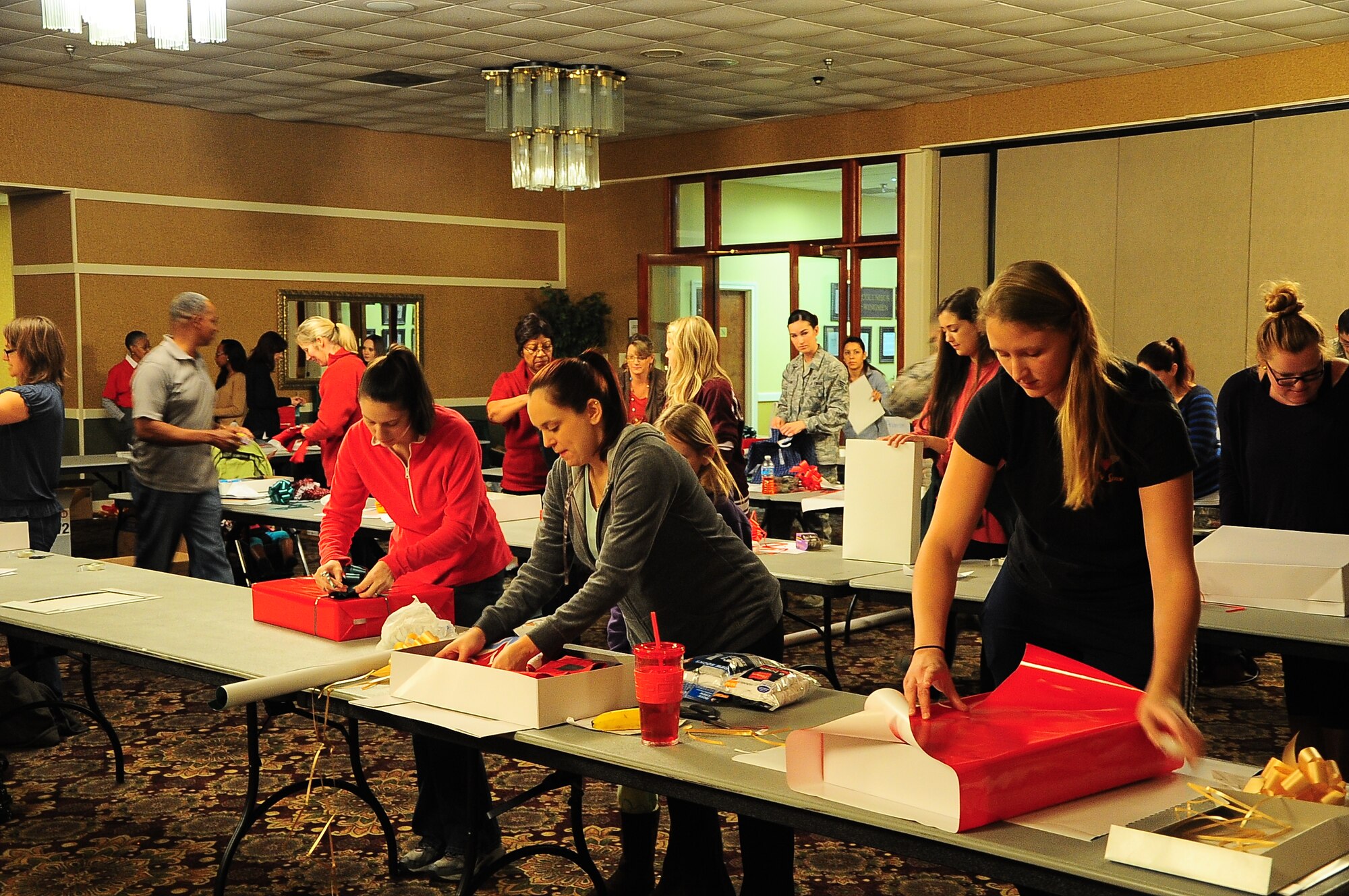 Airmen and local volunteers wrap presents during the Happy Fund Shop and Wrap event Dec. 18 in the Columbus Club.  The presents wrapped this morning were delivered today.(U.S. Air Force Photo/Senior Airman Stephanie Englar)