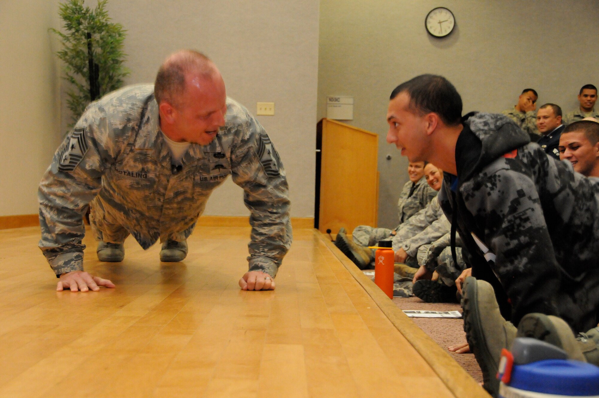 Chief Master Sgt. James W. Hotaling, command chief master sergeant of the Air National Guard, performs push-ups with newly recruited Kaimana Mattson, Hawaii Air National Guard, during a Town Hall Meeting at Joint Base Pearl Harbor Hickam on Nov. 9, 2014. Mattson is a prospective recruit for the 203rd Air Refueling Squadron in student flight and is awaiting orders for Basic Military Training. (U.S. Air National Guard photo by Airman 1st Class Robert Cabuco)
