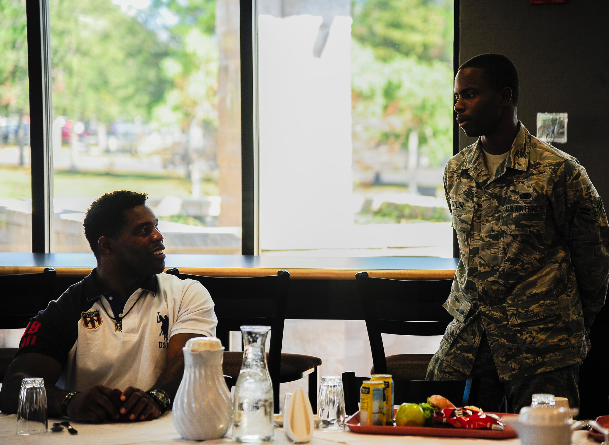 Herschel Walker, former Heisman trophy winner and retired NFL football player, listens as Airman 1st Class Jordane Taylor, 6th Logistics Readiness Squadron, introduces himself during a luncheon at MacDill Air Force Base, Fla., Dec. 17, 2014. Walker visited MacDill to share his story of hope about overcoming challenges and not being afraid to seek help when needed. (U.S. Air Force photo by Senior Airman Vernon L. Fowler Jr./Released)