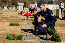 Staff Sgt. Dereck Reeves, 4th Maintenance Group plans and scheduling specialist, lays a wreath on a veteran’s grave during National Wreaths Across America Day at Evergreen Memorial Cemetery in Princeton, North Carolina, Dec. 13, 2014. The event was part of the Wreaths Across America mission, which delivered hundreds of thousands of remembrance wreaths to more than 900 cemeteries across the country in honor of our nation’s fallen heroes. (U.S. Air Force photo by Airman 1st Class Brittain Crolley)