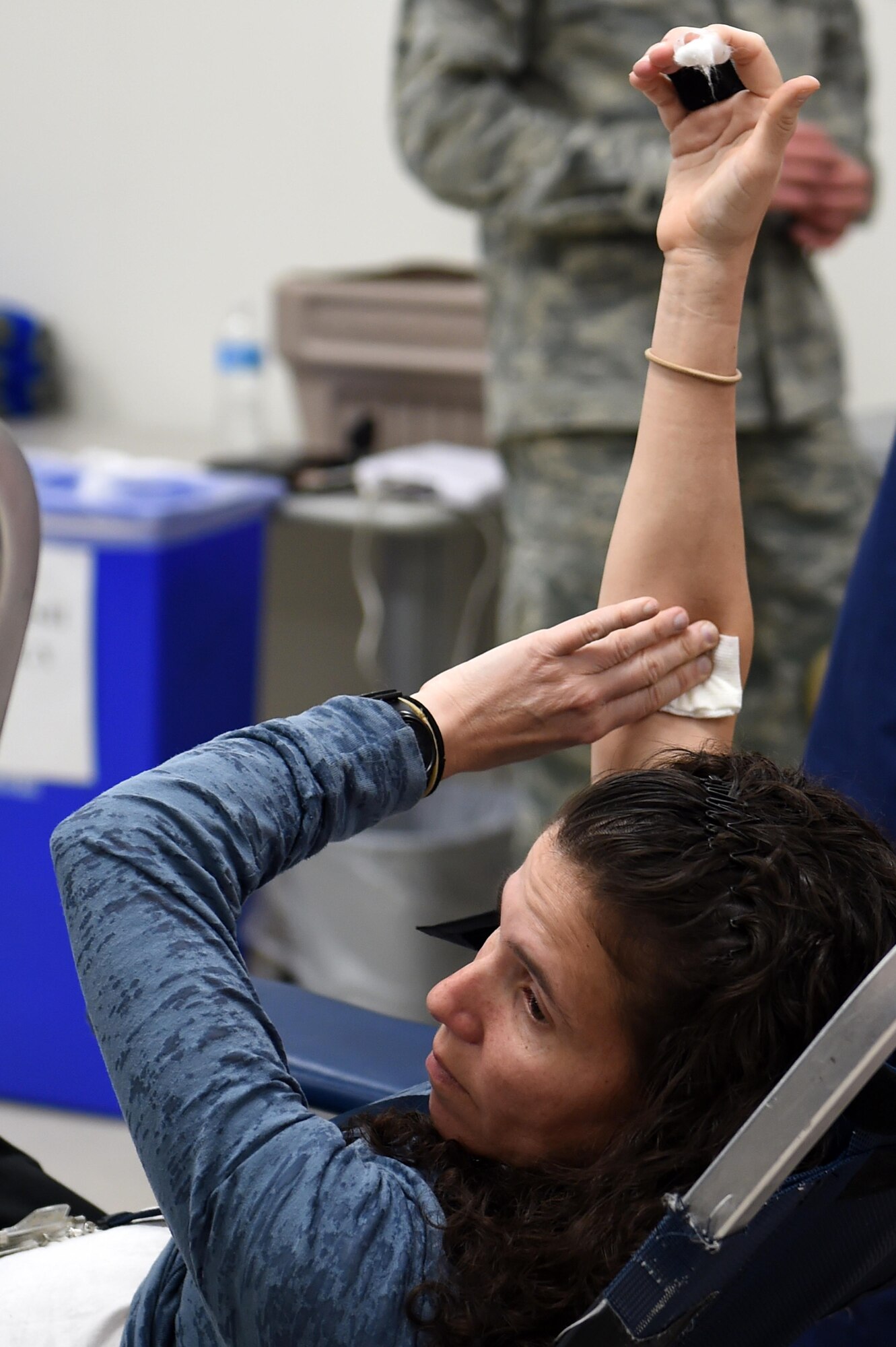 Celiann Gonzalez, 460th Civil Engineer Squadron asset management chief, applies pressure to her arm during the Bonfils Blood Center blood drive Dec. 17, 2014, at the Buckley Health Promotions Program. Many Team Buckley members attended the blood drive to raise awareness for the need of blood donors. (U.S. Air Force photo by Airman 1st Class Emily E. Amyotte/Released)