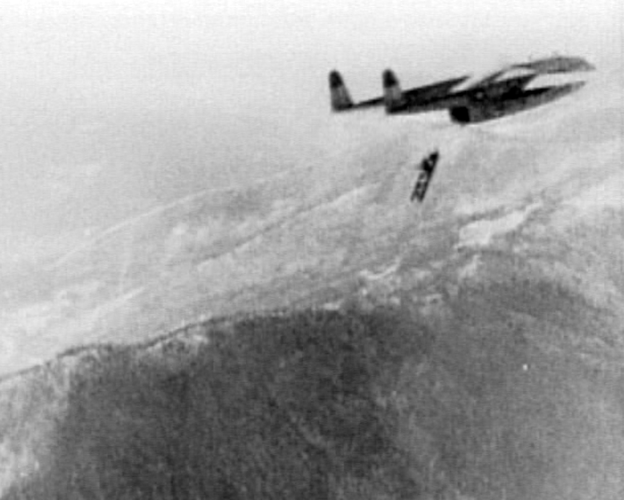 An M-2 Treadway Bridge section is dropped from the door of a C-119 assigned to the 314th Troop Carrier Group, 61st Troop Carrier Squadron over Koto-ri, North Korea Dec. 7, 1950. Rear clamshell doors of the C-119 were removed to accommodate the outsize bridge sections. (Courtesy Photo)