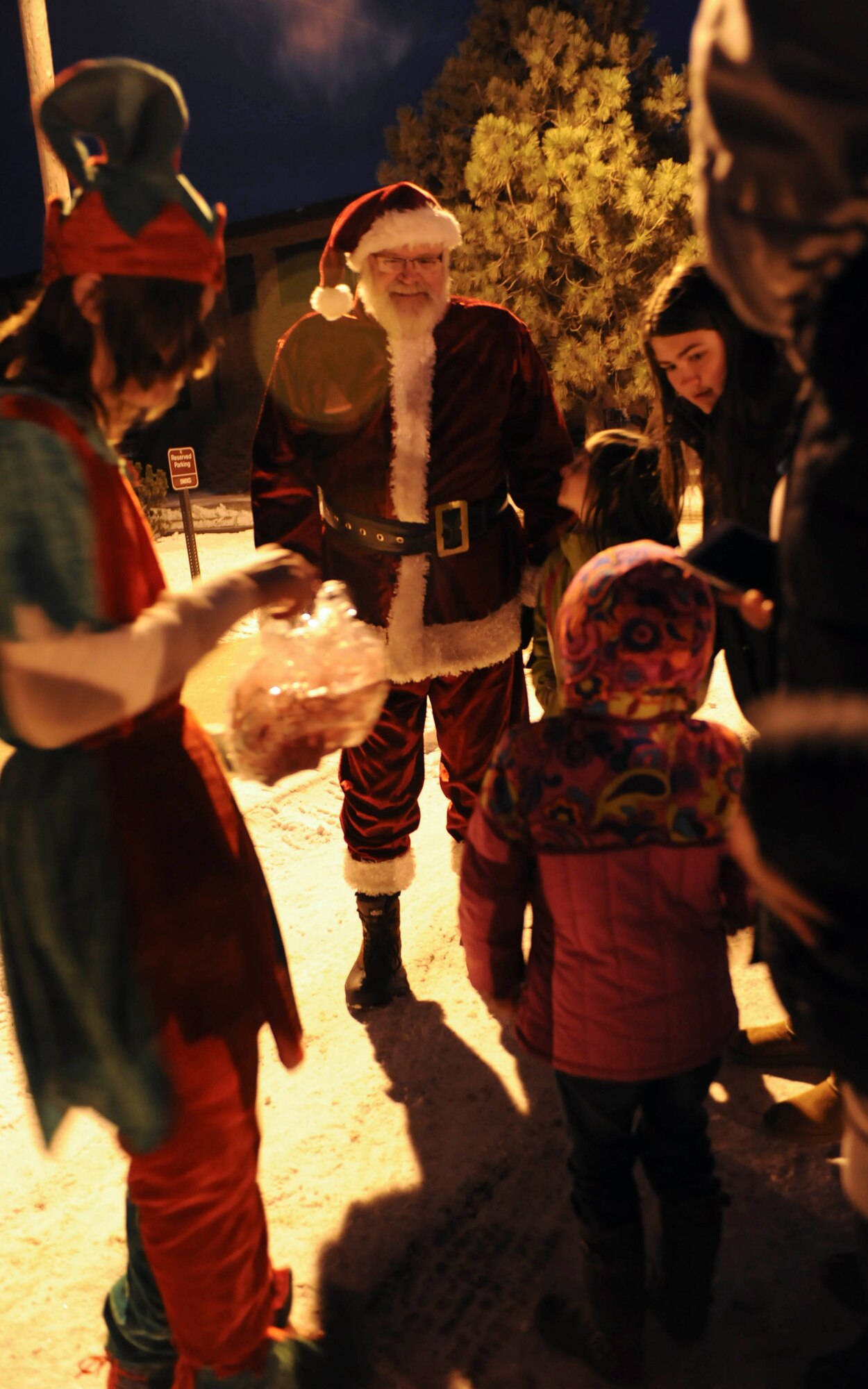 Santa Claus greets a young girl during the holiday tree lighting event hosted at the Jimmy Doolittle Center on Minot Air Force Base, N.D., Dec. 6, 2014. St. Nick arrived at the tree lighting aboard fire engine number 12 and welcomed children at the event with a smile and candy canes provided by one of his elves. (U.S. Air Force photo/Senior Airman Stephanie Morris)
