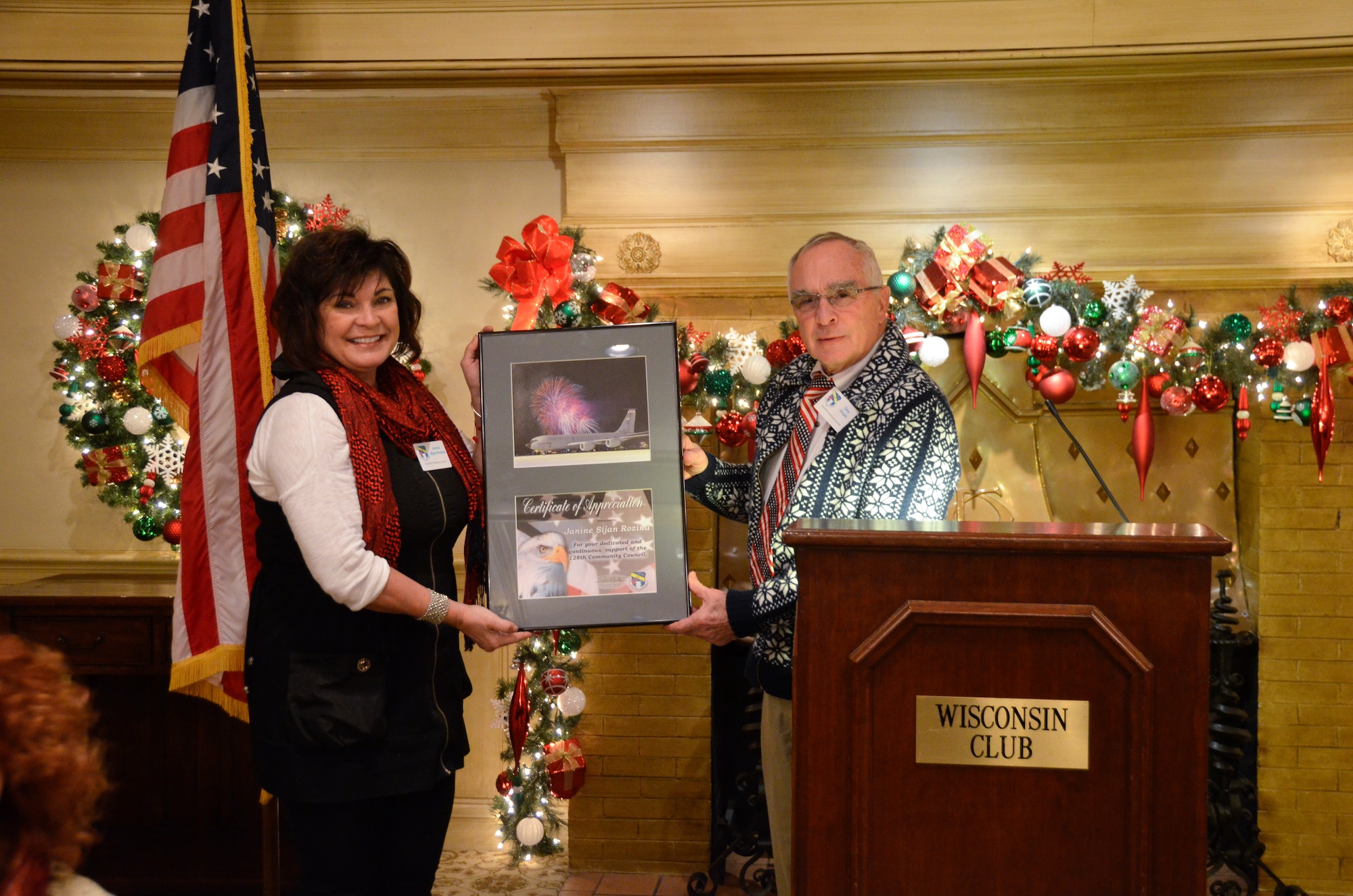 Janine Sijan Rozina receives a Certificate of Appreciation during a 128th Community Council general membership meeting held at the Wisconsin Club, Milwaukee, Dec. 12, 2014 from Gary Glojek, chairman of the 128th Community Council, for her dedication as a board member for the past two years. (U.S. Air National Guard photo by Maj. Sherri A. Hrovatin/Released)