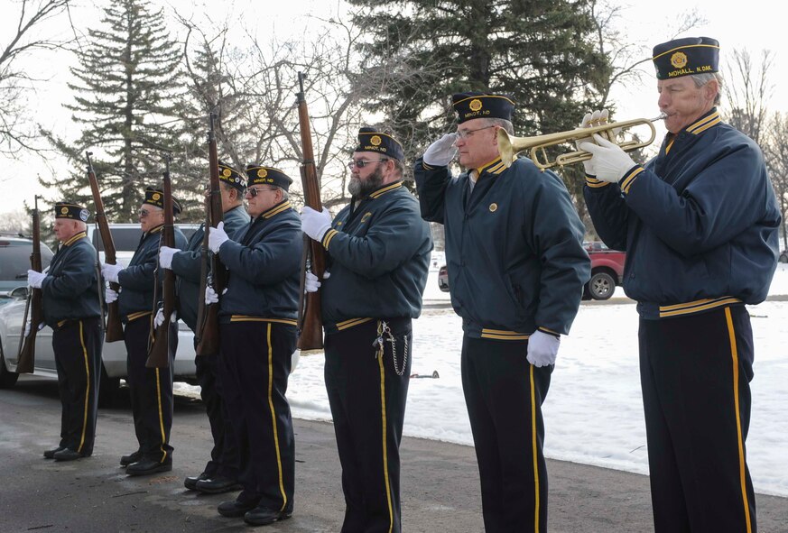 Veterans from the city of Minot and other surrounding communities stand at attention as TAPS is played during a ceremony commemorating national Wreaths Across America Day at Rosehill Memorial Park Cemetery in Minot, N.D., Dec. 13, 2014. Moments before, the group had rendered a 12-gun salute in honor of veterans buried at Rosehill. (U.S. Air Force photo/Senior Airman Stephanie Morris)