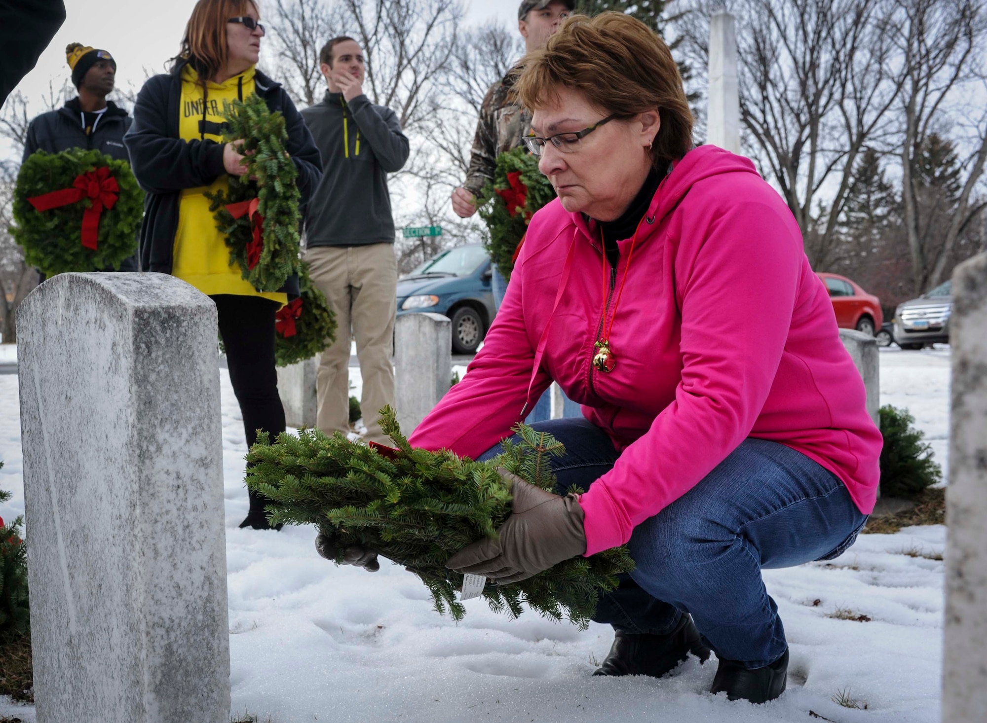 Minot native Lori Ammon places a wreath at the grave of Peter Grindberg during a ceremony commemorating national Wreaths Across America Day at Rosehill Memorial Park Cemetery in Minot, N.D., Dec. 13, 2014. Grindberg was a private first class who served in the 12 Field Hospital First Division, and he was one of many U.S. service members who had no recorded date of death on their headstone who may have been missing in action. (U.S. Air Force photo/Senior Airman Stephanie Morris)