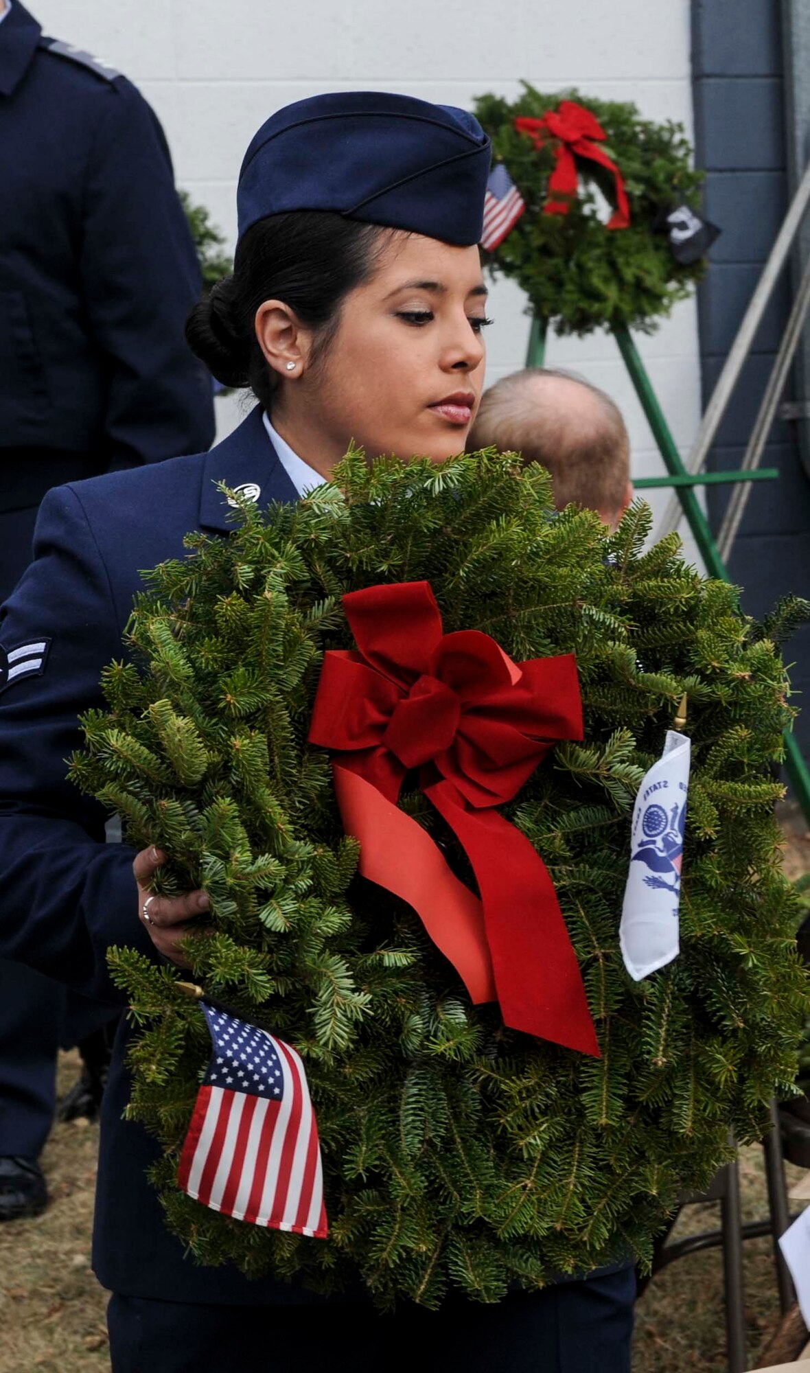 Airman 1st Class Rebekah Oyerbides, 5th Medical Group, carries a ceremonial wreath during national Wreaths Across America Day at Rosehill Memorial Park Cemetery in Minot, N.D., Dec. 13, 2014. Oyerbides stated that she volunteered to help with the event because she wanted to help honor those who came before her and gave so much. (U.S. Air Force photo/Senior Airman Stephanie Morris)