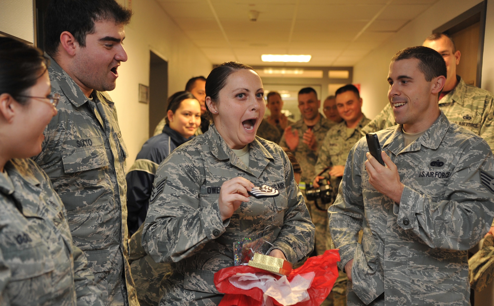 Staff Sgt. Lacy Owens, 86th Medical Group element b NCOIC, is speechless when she opens her gift and sees Tech. Sgt. stripes at Ramstein Air Base, Germany, Dec. 12, 2014. Owens was given a STEP promotion by the base commander for exceptional performance. (U.S. Air Force photo/Senior Airman Hailey Haux)