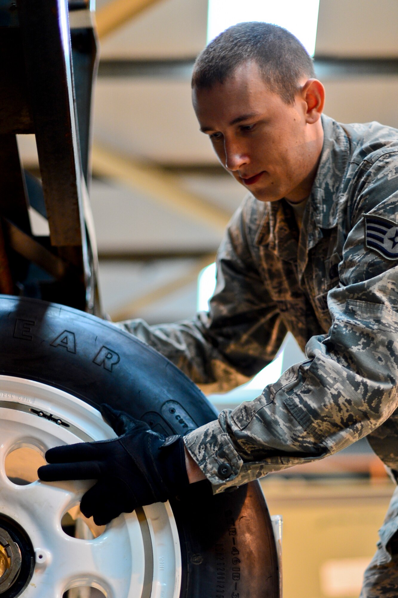 Staff Sgt. Dominic Piazza, 48th Logistic Readiness Squadron readiness spares supervisor, removes an F15-E Strike Eagle tire from a tire rack at Royal Air Force Lakenheath, England, Dec. 18, 2014. Piazza was nominated for a Liberty Spotlight because he embodies the core value of Service Before Self. (U.S. Air Force photo by Airman 1st Class Erin R. Babis/Released)