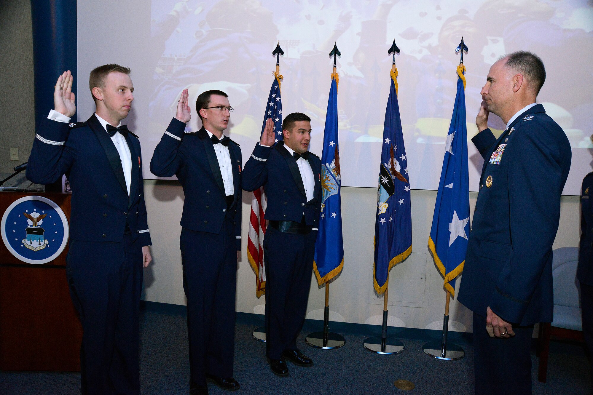 Vice Commandant of Cadets Col. Dale Holland administers the oath of office to three newly-minted second lieutenants at the Cadet Graduation and Commissioning Ceremony here Dec. 17, 2014. The new Air Force 2nd Lt.’s are Aaron Hall of Duncanville, Texas; Adam McMurray of Huntsville, Ala.; Christopher Morales of Rio Rancho, N.M.; and Michael Husar, Jr. of Chicago. Husar, a Falcons Football lineman, was training for the Dec. 20 matchup against Western Michigan in the Famous Potato Bowl in Idaho and did not attend the ceremony.  (U.S. Air Force photo/Jason Gutierrez)