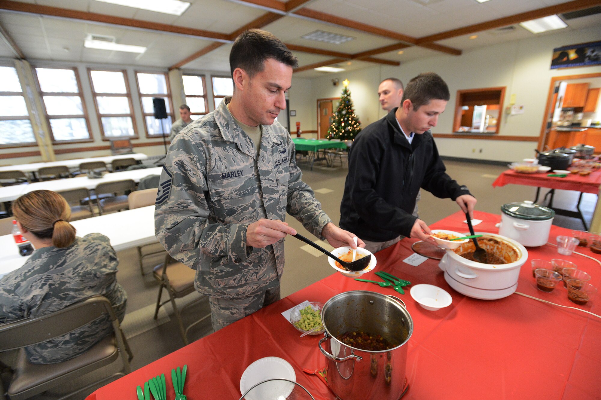 Master Sgt. Aaron Marley, superintendent of the Hanscom Honor Guard, scoops chili into his bowl during a chili cook-off at the Hanscom Air Force Base, Mass., chapel, Dec. 17, 2014.  Staff Sgt. Emma Bryne, 66th Medical Squadron health services management, took first place in the cook-off. (U.S. Air Force photo by Jerry Saslav)
