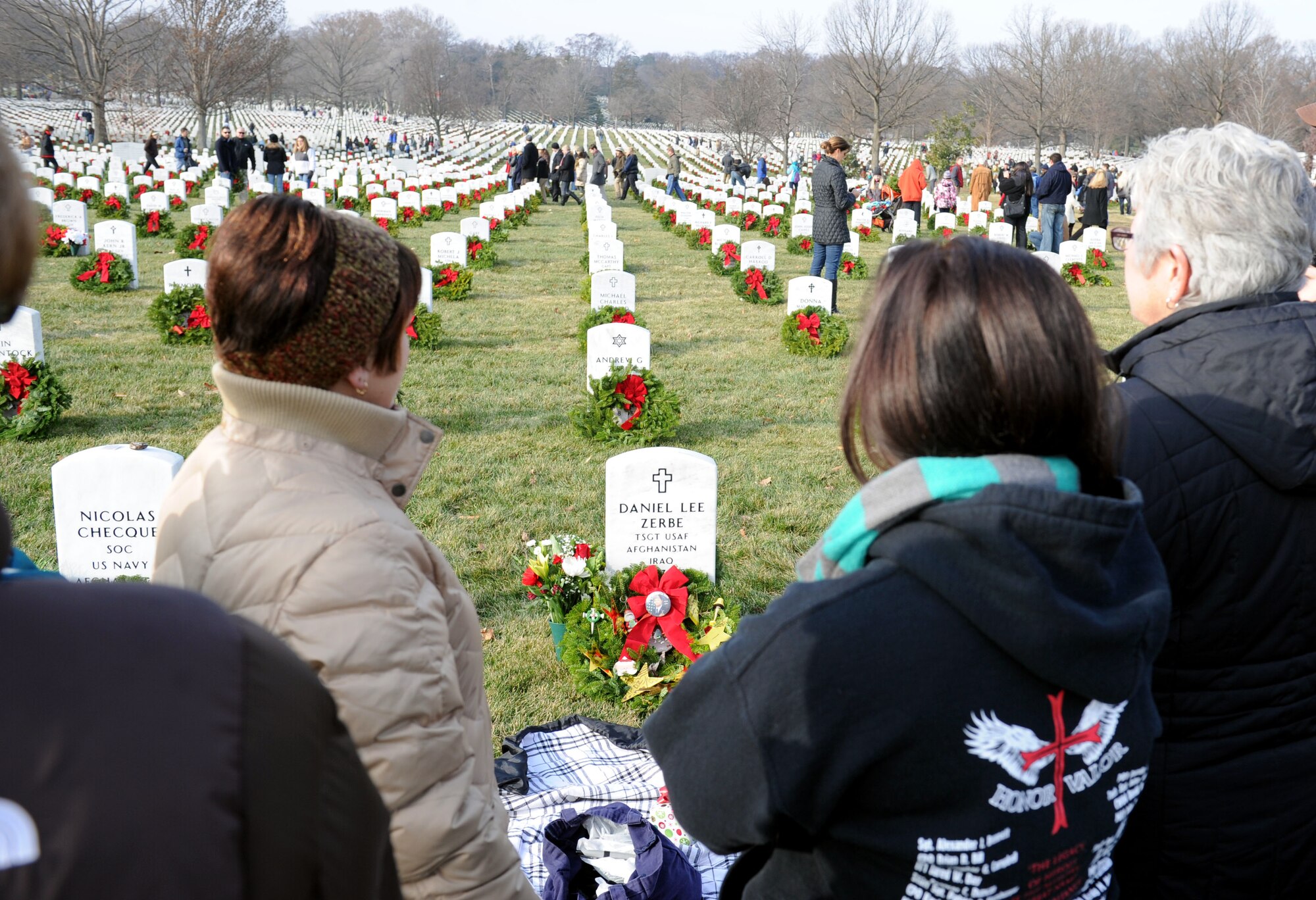 Susan Zerbe, left, and Megan Zerbe, middle, look down at Tech. Sgt. Daniel Zerbe’s grave after laying a wreath on it during the 23rd Annual National Wreaths Across America Day on Dec. 13, 2014, at Arlington National Cemetery, Virginia. Susan is Daniel’s mother and Megan is his sister. Airmen from all around the Washington area, along with friends and families of fallen warriors, were among the nearly 50,000 volunteers to place remembrance wreaths on the headstones of about 230,000 veterans. (U.S. Air Force photo/Staff Sgt. Christopher Gross)