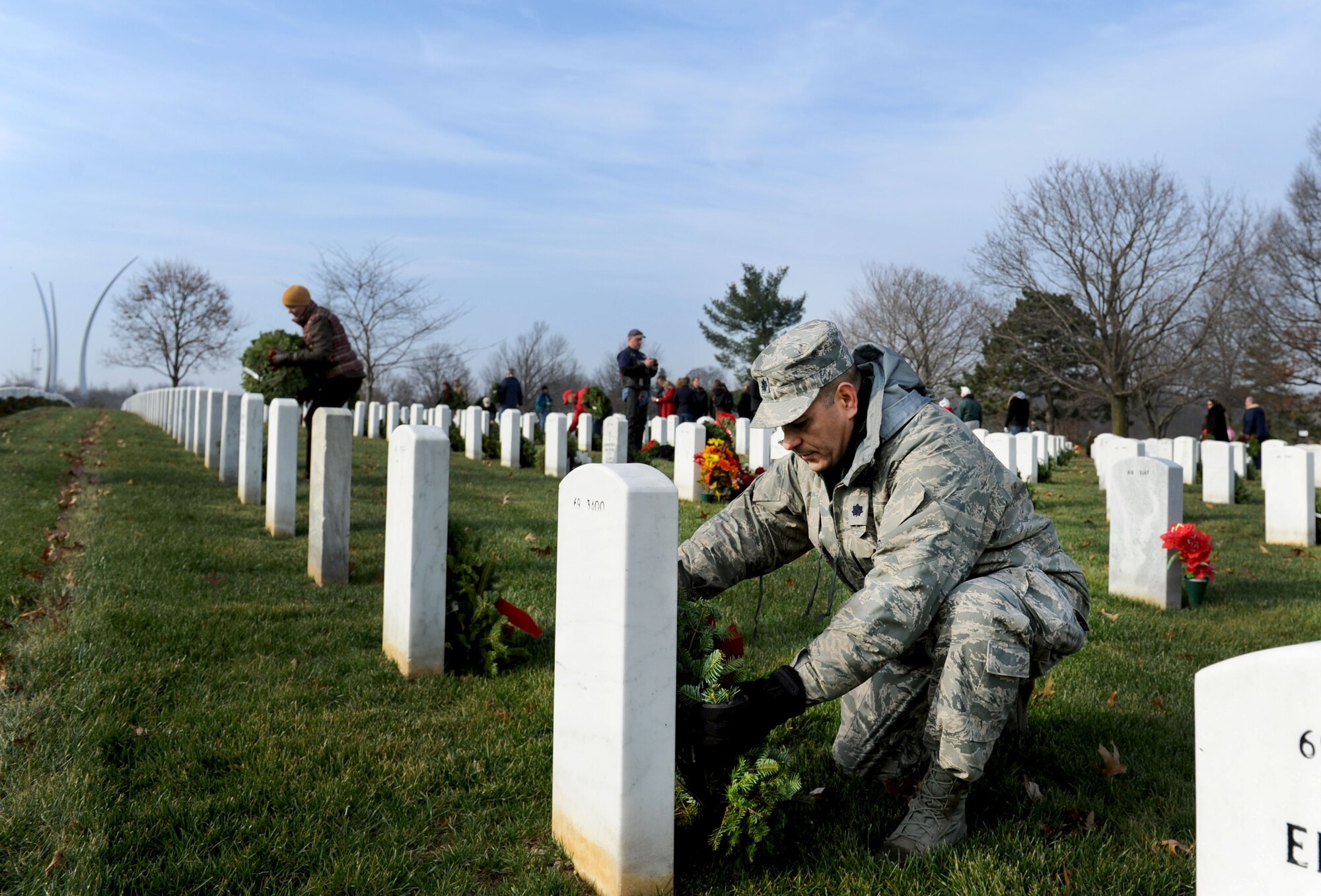 Lt. Col. David Burnett lays a wreath on a tombstone during the 23rd Annual National Wreaths Across America Day on Dec. 13, 2014, at Arlington National Cemetery, Virginia. Burnett is assigned to the Joint Staff, J1, Plans and Readiness Personnel Readiness Division at the Pentagon, and was one of the nearly 50,000 volunteers at Arlington. (U.S. Air Force photo/Staff Sgt. Christopher Gross)