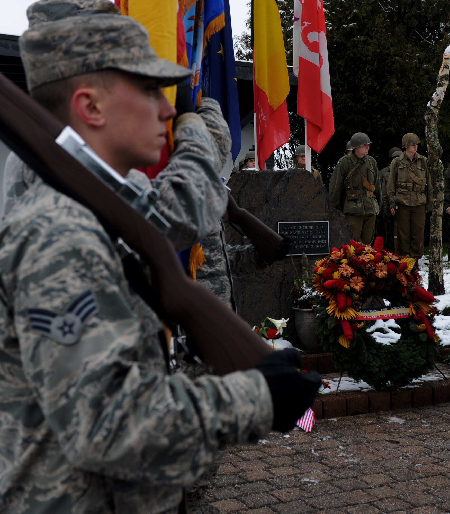 Spangdahlem honor guard members and Battle of the Bulge reenactors stand next to the U.S. Army 106th Infantry Division monument during a memorial ceremony at St. Vith, Belgium, Dec. 14, 2014. The ceremony consisted of a presentation of multiple wreaths, an invocation and speeches from the veterans. (U.S. Air Force photo by Airman 1st Class Luke Kitterman/Released) 
