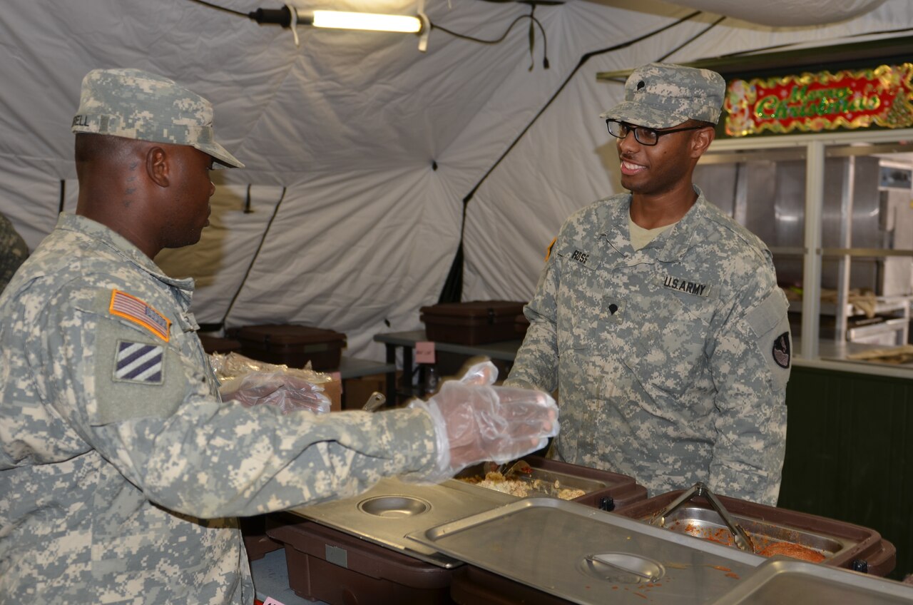 Army Sgt. William Burrell, left, mentors Army Spc. Benjamin Ross in food service at the National Police Training Academy in Paynesville, Liberia, Dec. 15, 2014. U.S. Army photo by Sgt. Ange Desinor