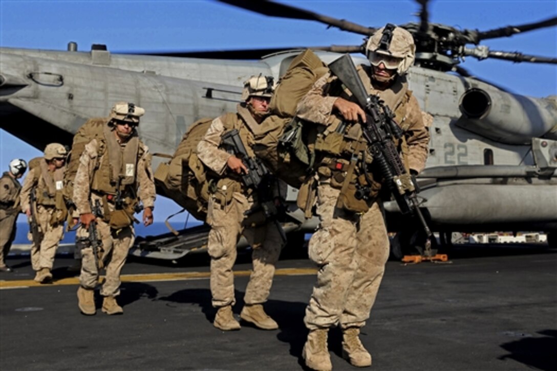 U.S. Marines exit from a CH-53E Super Stallion on the amphibious assault ship USS Makin Island in the U.S. 5th Fleet area of responsibility, Dec. 12, 2014. The Marines are assigned to Golf Company, Battalion Landing Team, 2nd Battalion, 1st Marine Regiment, 11th Marine Expeditionary Unit.