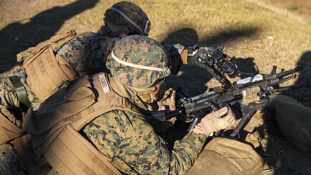 Lance Cpl. Edwin Centofanti, a machine-gunner with 1st Battalion, 8th Marine Regiment and native of Youngstown, Ohio (left), loads and closes an M249 light machine gun for Lance Cpl. Michael Hobbs, an anti-tank missleman with the battalion and native of Phoenix, Arizona, during a unit training exercise held at G-21 Machine Gun Range, aboard Camp Lejeune, N.C., Dec. 11, 2014. Marines conducted this training to keep up weapon system knowledge and improve on their skills with the machine gun to remain prepared to hold up the battalion’s purpose during deployments.